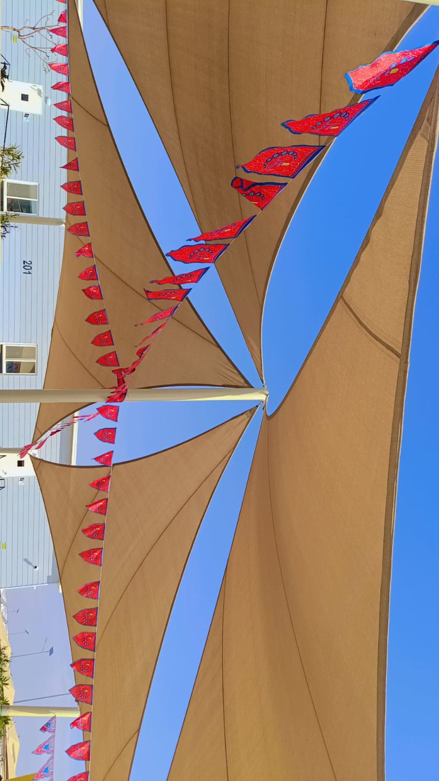 Sail style sun shades with tensioned membrane geometry